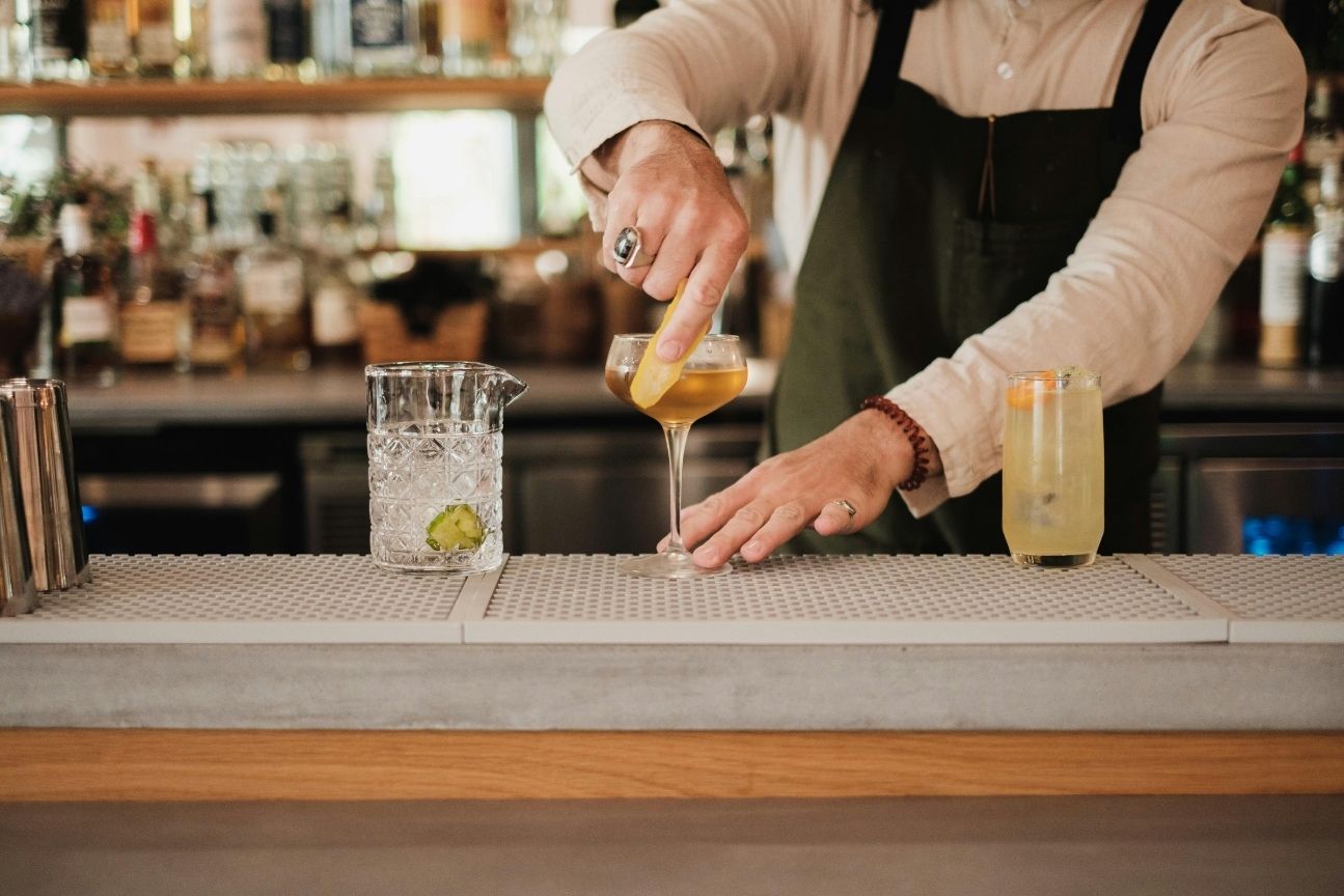bartender al bancone in un cocktail bar di Milano